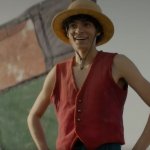 Pirat Ruffy steht mit der ikonischen roten Weste und Strohhut vor einem geflickten Segel. Er hat wie immer einen optimistischen Gesichtsausdruck.