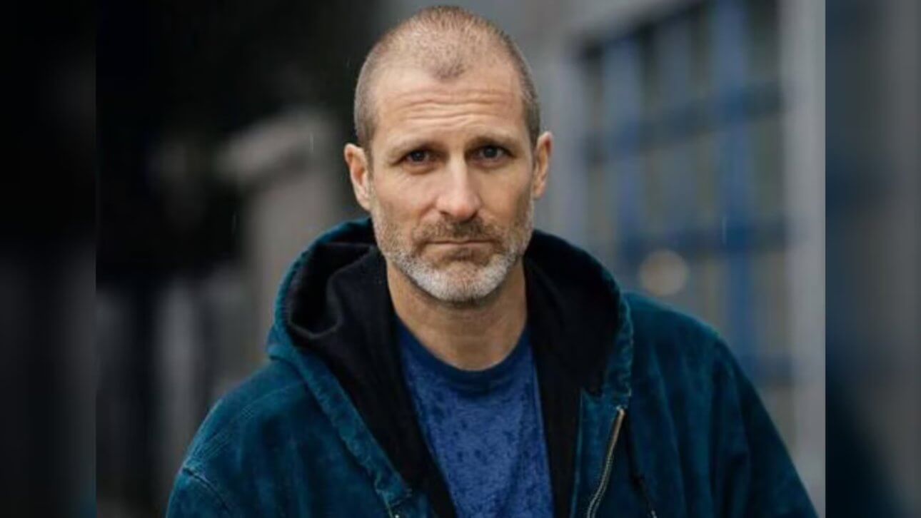 Der Schauspieler Stewart McLean blickt in die Kamera. Er trägt einen Kapuzenpullover.