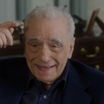 Martin Scorsese trägt einen dunklen Anzug und gestikuliert.