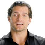 Henry Cavill Breaks Down The Blaviken Fight Scene Shot By Shot: hollywood-Star Henry Cavill sitzt vor einem hellen Hintergrund und erklärt, wie eine Kampfszene in der Netflix-Serie The Witcher entstanden ist.