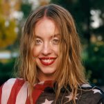 EUPHORIA Staffel 3: Sydney Sweeney steht in einem Garten, trägt die US-Flagge als Oberteil und ihre Haare sind etwas durcheinander.