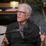 Ted Danson sitzt im Podcast-Studio. Vor ihm befindet sich ein Mikrofon.