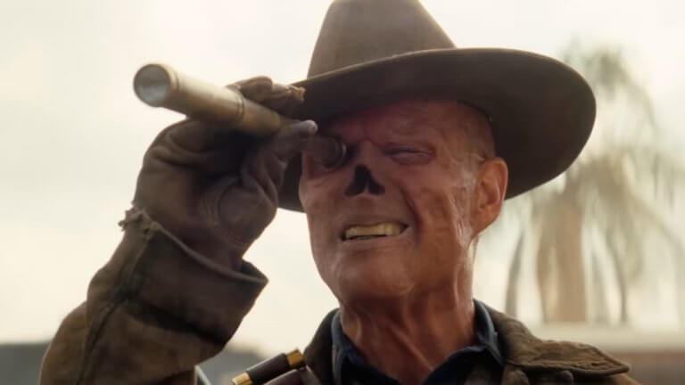Fallout Staffel Zwei : Walton Goggins als Ghoul blickt durch ein Fernglas, um die Umgebung auzukundschaften.
