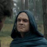 House of the Dragon | S3 - EP.2: eine Gestalt mit Kapuze, mit starken Brandnarben, steht im Wald und wirkt unzufrieden.