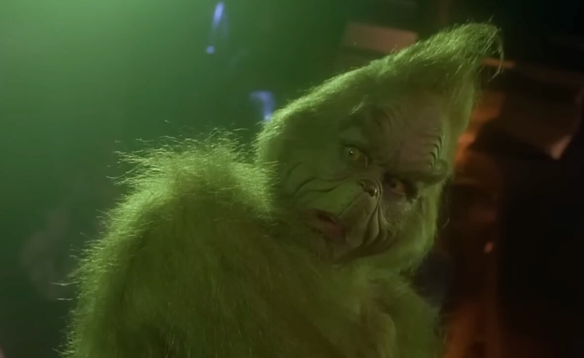 How the Grinch Stole Christmas: Jim Carrey als Grinch steht in einer düsteren Höhle.
