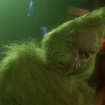 How the Grinch Stole Christmas: Jim Carrey als Grinch steht in einer düsteren Höhle.
