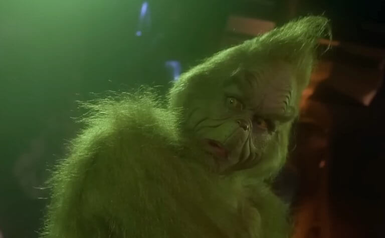 How the Grinch Stole Christmas: Jim Carrey als Grinch steht in einer düsteren Höhle.