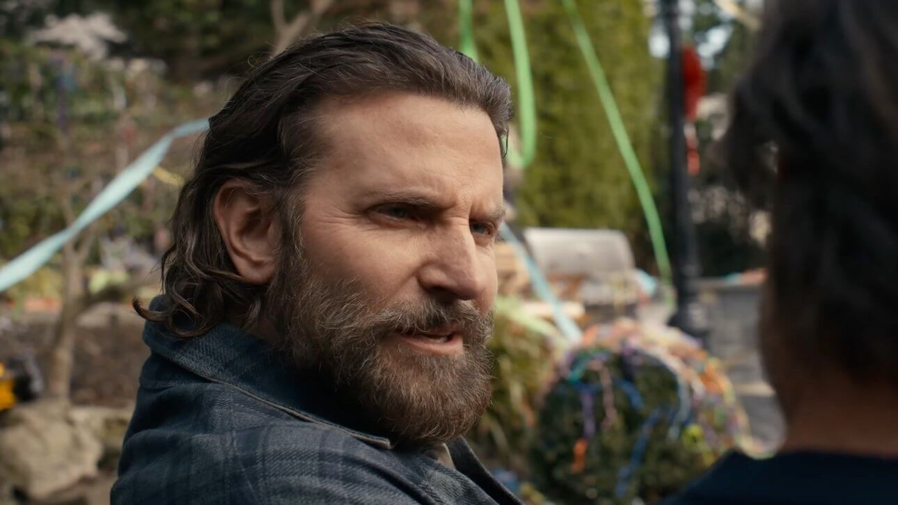 IS THIS THING ON? Bradley Cooper trägt einen Vollbart und sitzt mit seinem Co-Darsteller im Garten.