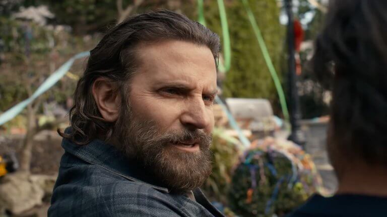 IS THIS THING ON? Bradley Cooper trägt einen Vollbart und sitzt mit seinem Co-Darsteller im Garten.