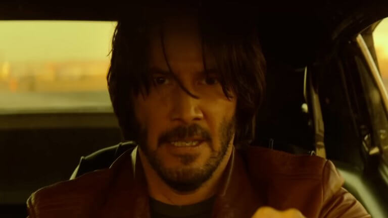 John Wick (2014): Keanu Reeves in seiner Rolle als John Wick. Er sitzt hinter dem Steuer seines Autos und wirkt fest entschlossen.