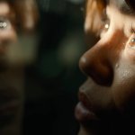 KLARA AND THE SUN: die von Jenna Ortega gespielte Figur namens Klara blickt durch ein Fenster. Ihr Spiegelbild ist in der Glasscheibe zu erkennen.