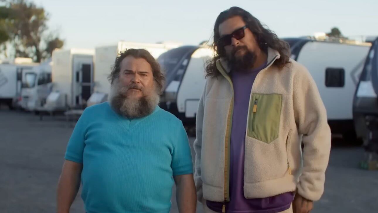 MINECRAFT 2: SQUARED: Jack Black und Jason Momoa blicken gespannt in die Kamera. Im Hintergrund sind Camping-Fahrzeuge zu sehen.