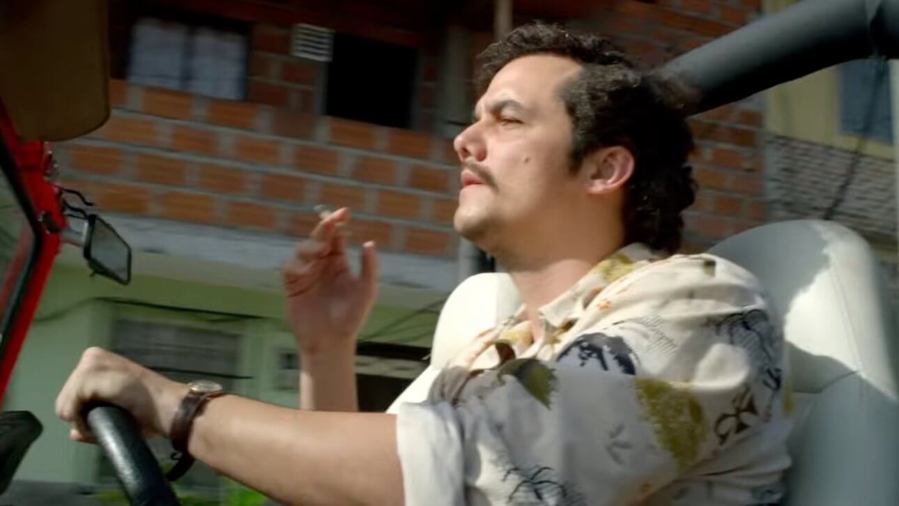 Narcos: Wagner Moura als Pablo Escobar sitzt in seinem Jeep und raucht beim Fahren.