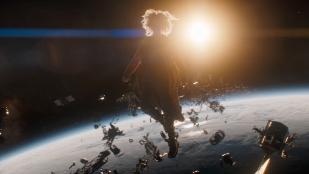 Supergirl: Supergirl schwebt im Orbit der Erde, umgeben von Weltraumschrott. Im Hintergrund ist die Sonne erkennbar.