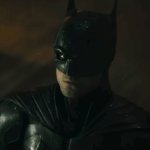 THE BATMAN: Robert Pattinson im Batman-Kostüm von schräg oben fotografiert. Er wirkt entschlossen.