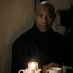 THE EQUALIZER 3: Denzel Washington sitzt an einem Kaffeetisch und trägt ein schwarzes Hemd.