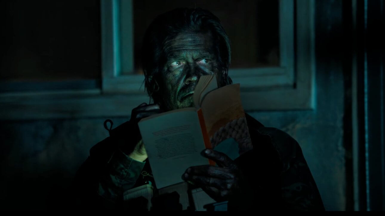 The Dog Stars: Josh Brolin sitzt in einem dunklen Raum und hält ein Buch in der Hand.