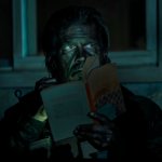 The Dog Stars: Josh Brolin sitzt in einem dunklen Raum und hält ein Buch in der Hand.