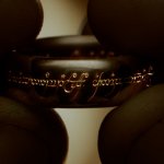 The Fellowship of the Ring | The Lord of the Rings: der eine Ring wird von zwei Daumen und zwei Zeigefingern gehalten.