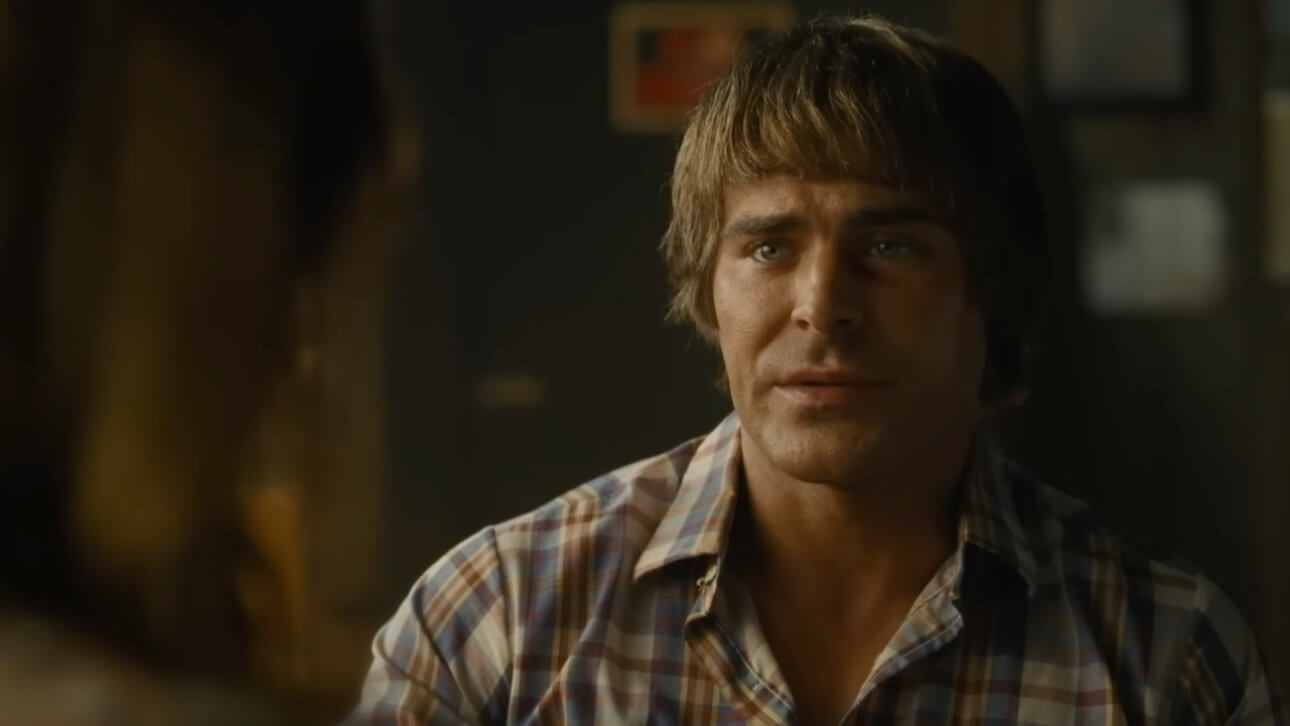 The Iron Claw: Zac Efron trägt ein kariertes Hemd und blickt ernst.
