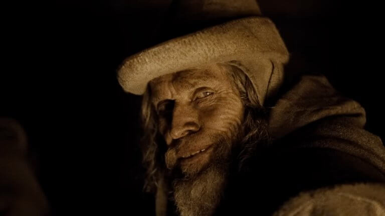 WERWULF: Willem Dafoe trägt ein mittelalterliches Kostüm und grinst in die Kamera.