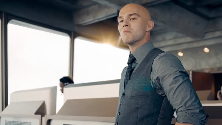 Superman: Lex Luthor steht im Kontrollraum und blickt verächtlich. Hinter ihm sitzen mehrere Angestellte an Bildschirmen und Kontrollpults.