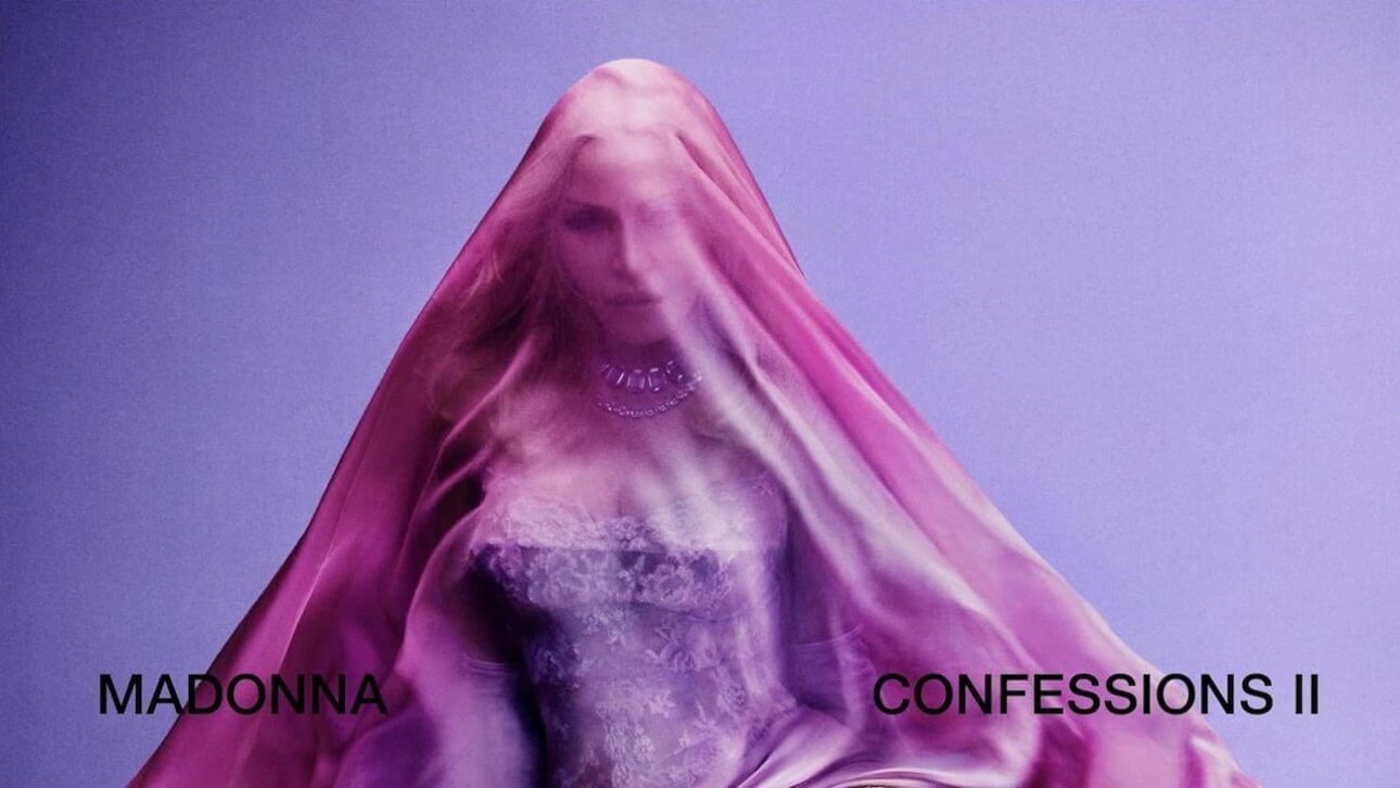 Confessions 2: Madonna sitzt vor einem lila Hintergrund und ist durch einen rosa Schleier verhüllt.