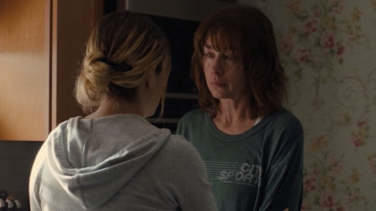 Mare of Easttown: Lori Ross ist traurig. Mit dem Rücken zur Kamera steht die Schauspielerin Kate Winslet.