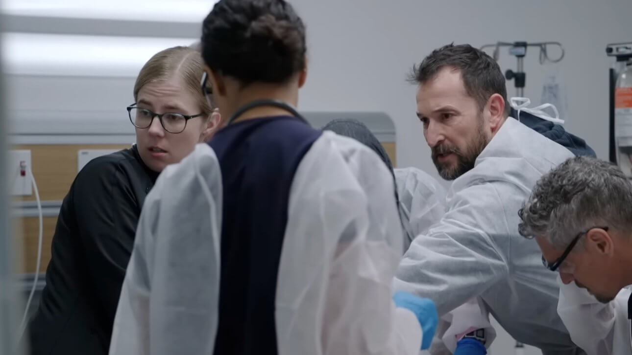 The Pitt: die Ärzte sind über einen Patienten gebeugt und versuchen, ihm das Leben zu retten.