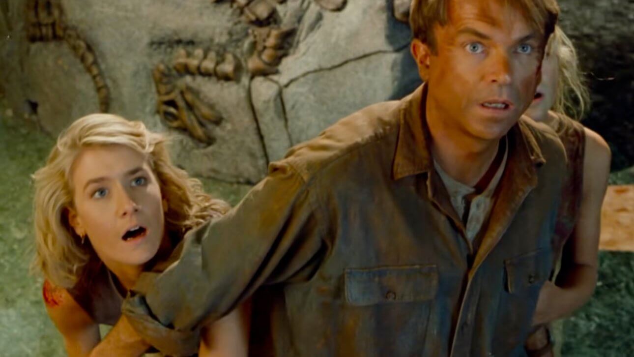 JURASSIC PARK: Sam Neill stellt sich schützend vor Laura Dern und ein kleines Mädchen.