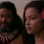 Moana: Moana und ein hawaiianischer Eingeborener stehen am Strand und unterhalten sich.