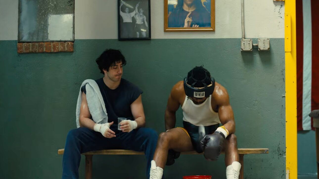 I Play Rocky: der Schauspieler Anthony Ippolito, der Rocky verkörpert, sitzt mit einem anderen Boxer auf der Bank.