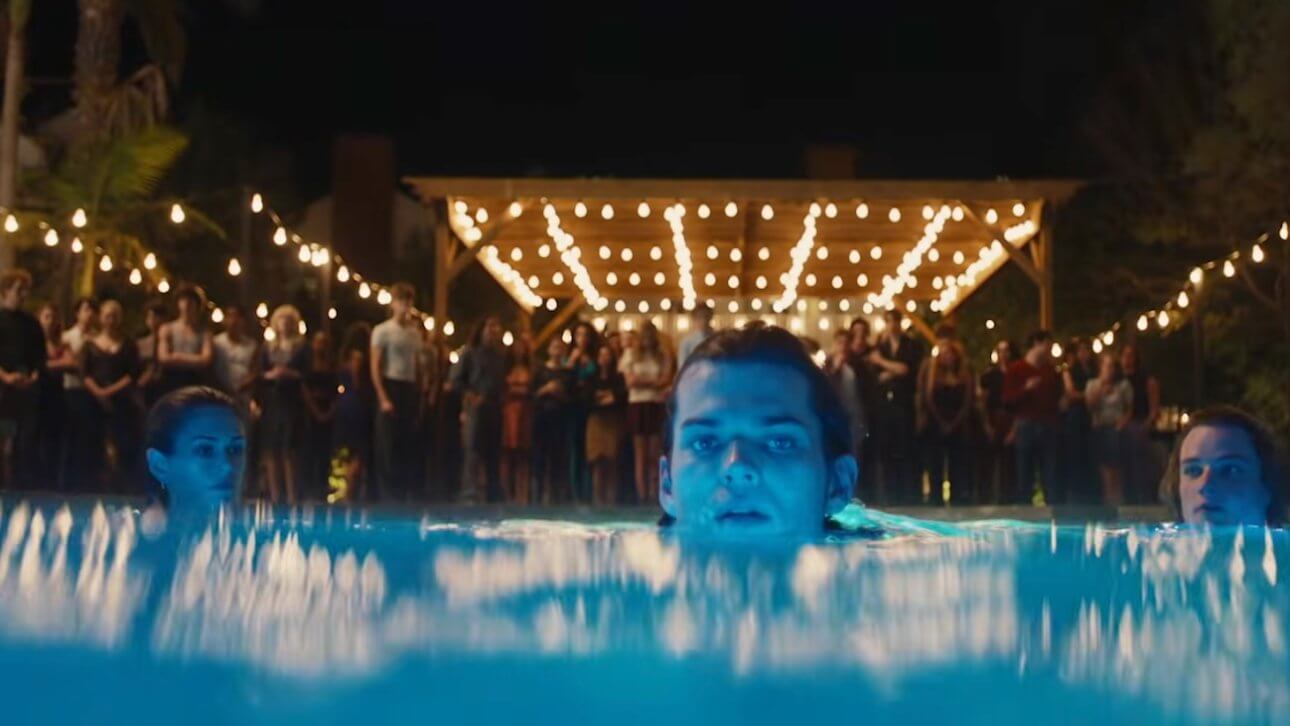The Shards I Offizieller Trailer: auf einer Gartenparty stehen viele Leute im Hintergrund. Drei junge Menschen schwimmen im Vordergrund im Swimming Pool.