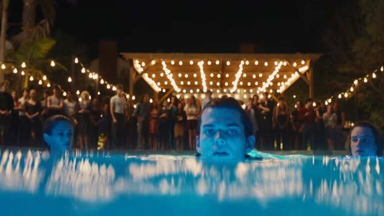 The Shards I Offizieller Trailer: auf einer Gartenparty stehen viele Leute im Hintergrund. Drei junge Menschen schwimmen im Vordergrund im Swimming Pool.