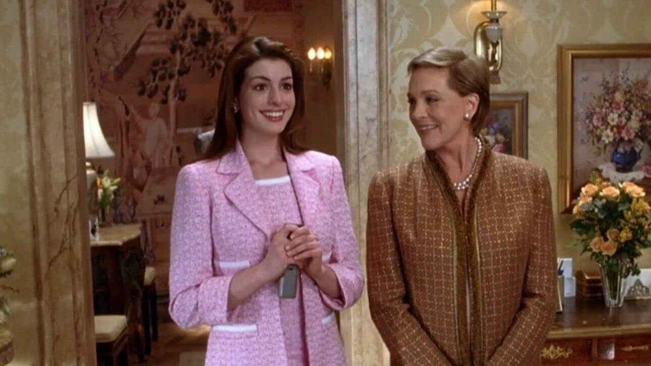 Plötzlich Prinzessin 2: Anne Hathaway trägt ein rosanes Outfit. Neben ihr ist eine etwas ältere Frau mit Perlenkette. Sie stehen in einem Raum, der sehr klassisch und luxuriös eingerichtet wurde.