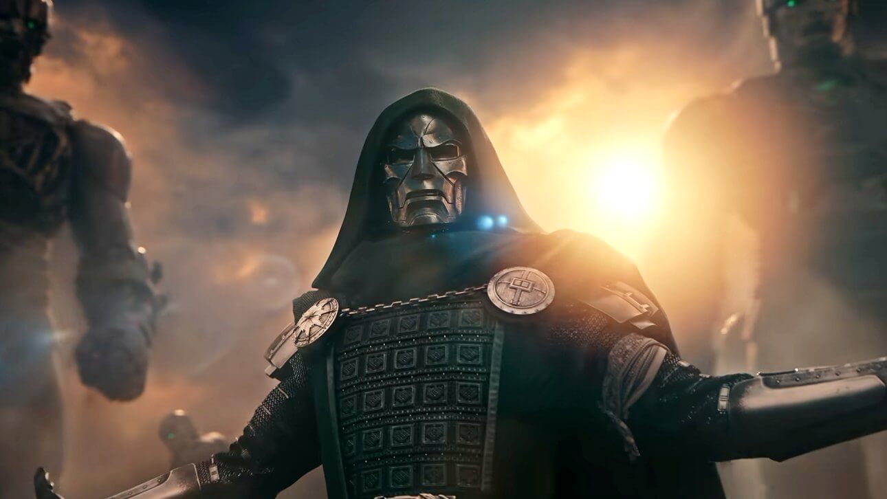 Victor von Doom breitet in voller Montur die Arme aus, während im Hintergrund gewaltige Roboter zu erkennen sind. Die Sonne strahlt über seine Schulter und er trägt die ikonische Maske mit seinem grünen Umhang.