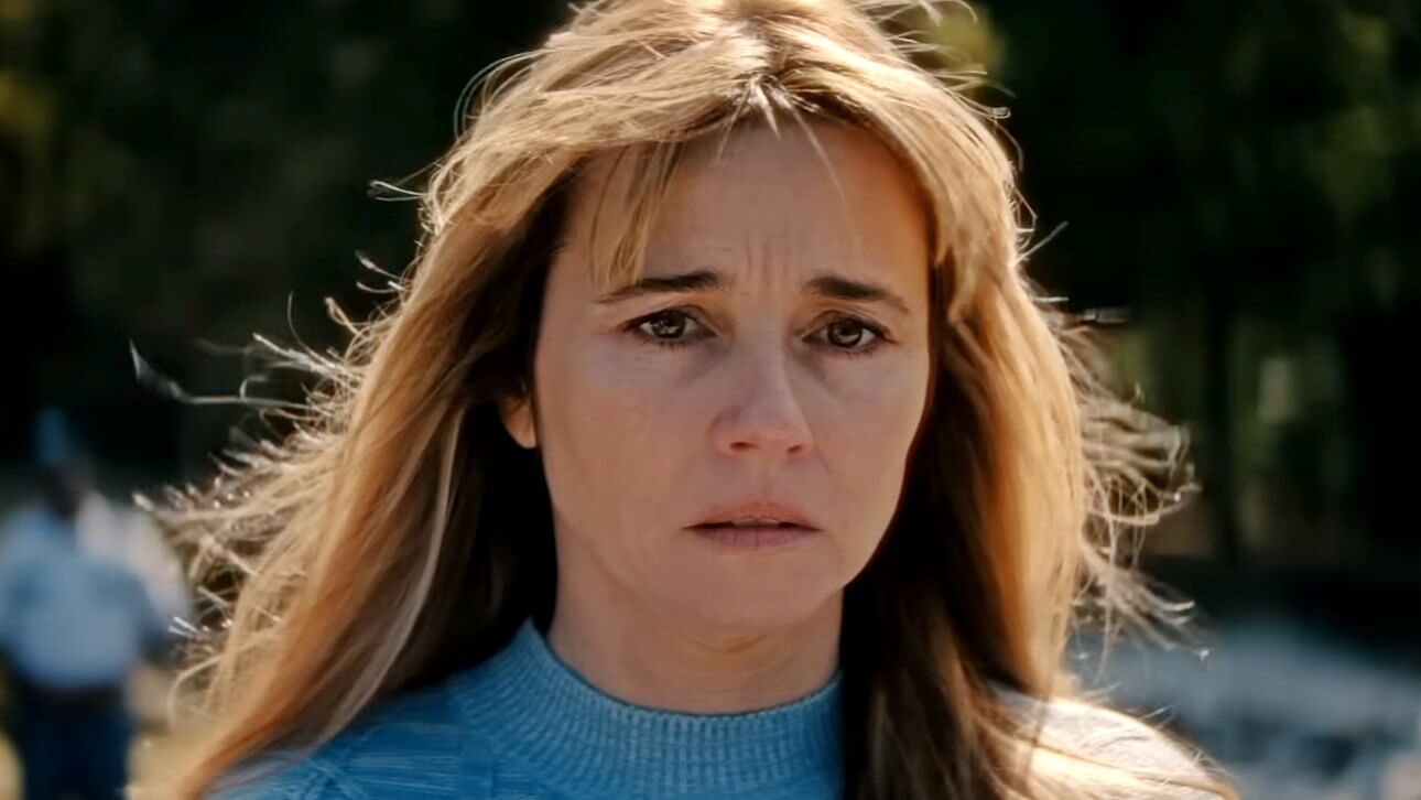 Linda Cardellini schaut mit traurigem und schokiertem Blick in Richtung Kamera. Hinter ihr nährt sich eine Person in Uniform.
