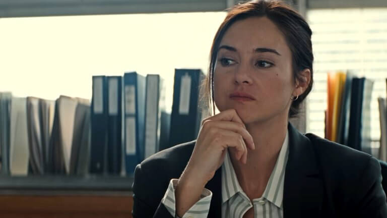Shailene Woodley blickt nachdenklich zur Seite. Hinter íhr sind mehrere Ordner vor einem großen Fenster zu sehen.