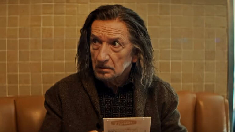 Sir Ben Kingsley blickt als Trevor Slattery nervös zur Seite.