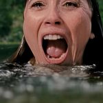 Linda Cardellini als Pam Voorhees schwimmt im Wasser und schreit entsetzt.