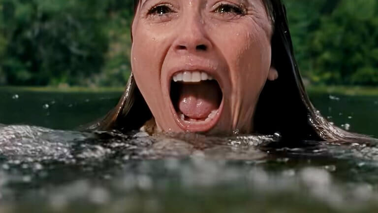 Linda Cardellini als Pam Voorhees schwimmt im Wasser und schreit entsetzt.