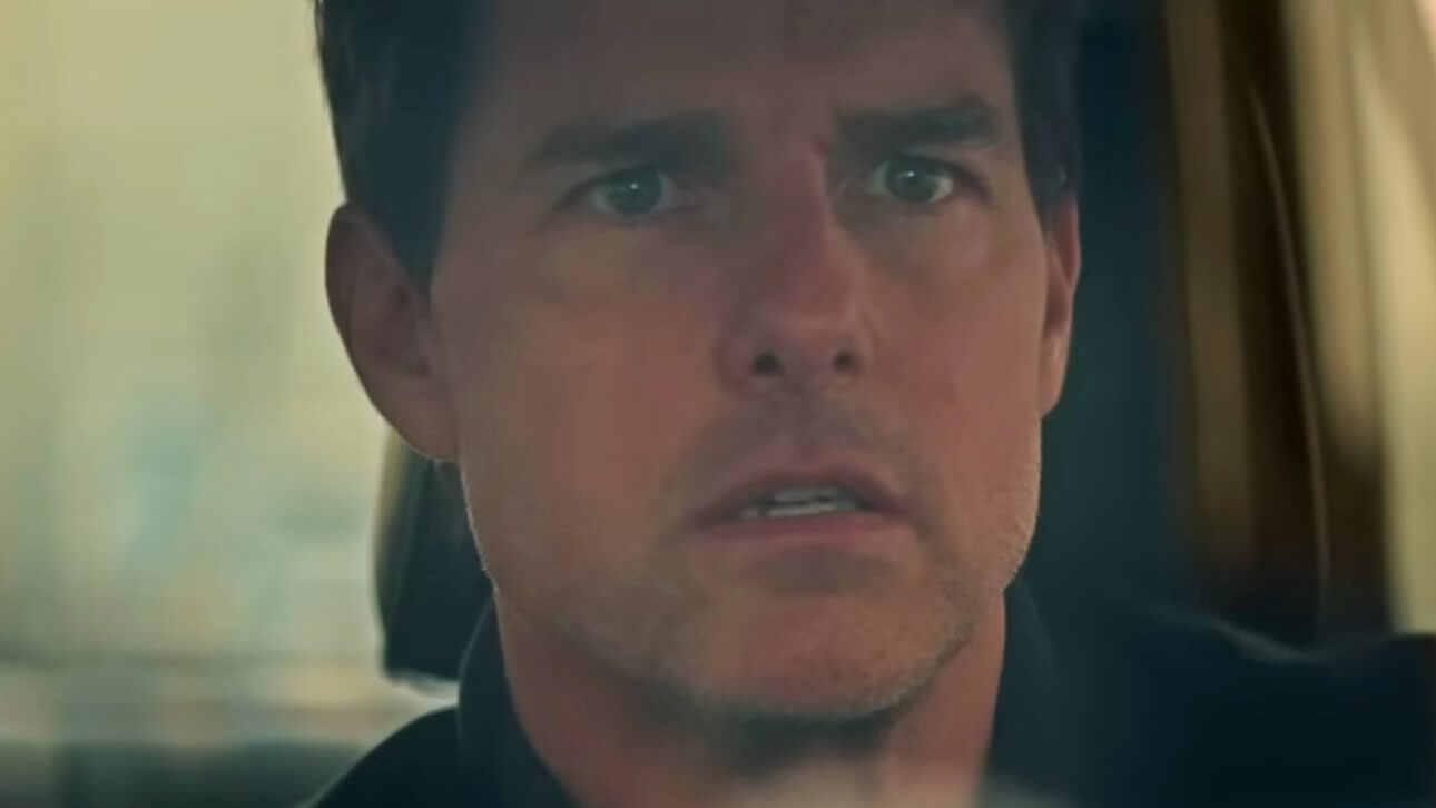 Tom Cruise sitzt in einem Auto und schaut schockiert durch die Frontscheibe. In seinem Blick liegen Unglaube und Resignation.
