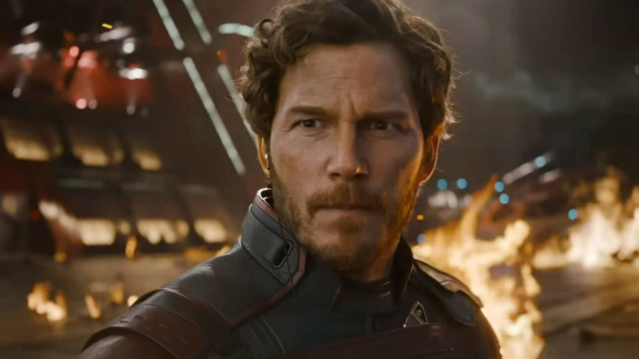 Peter Quill alias Star-Lord ist in seiner "Guardians of the Galaxy"-Uniform zu sehen. Er steht in einem brennenden Hangar und trägt Kopfhörer.