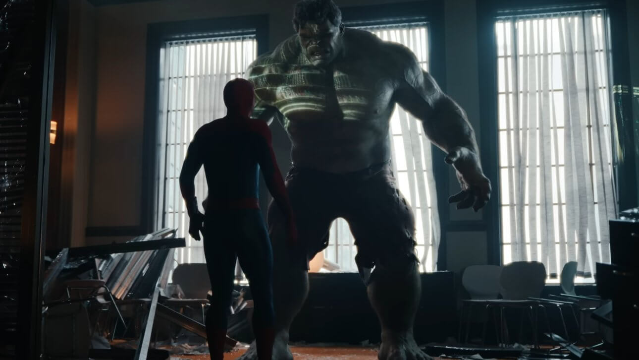 Der Hulk baut sich in all seiner Größe gegenüber Spider-Man auf. Sie stehen in einem verwüsteten Bürogebäude.