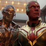 Vision steht mit seinen ikonischen roten, grünen und goldenen Farben in einem Haus. Hinter ihm ist die böse KI Ultron zu sehen, die ihn bedrohlich anstarrt.